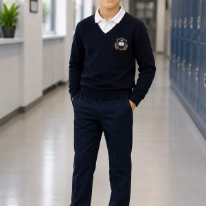 Băiat purtând pantaloni bleumarin EduWear pe holul școlii